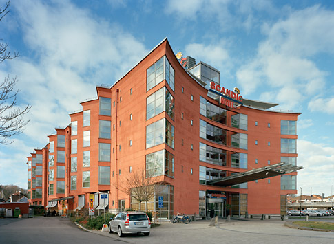 Nytt rött hotell med mycket glas i 5 våningar.