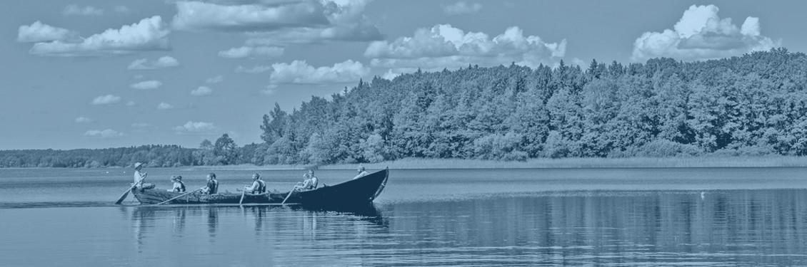 Dis - Släktforskning - Långbåt med åtta roddare, en i fören och en kvinna som håller i rodret längst bak.